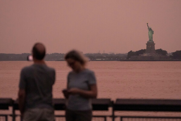 The Statue of Liberty is visible through haze due to Canadian wildfire smoke during sunset Aug. 5, 2025, in New York. (AP Photo/Yuki Iwamura, File)