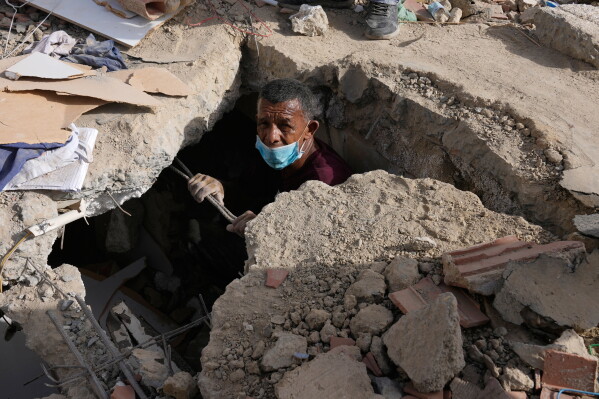 Franklin Fuentes searches for missing relatives in the collapsed building where they lived two days after earthquakes struck La Guaira, Venezuela, June 26, 2026. (AP Photo/Ariana Cubillos, File)
