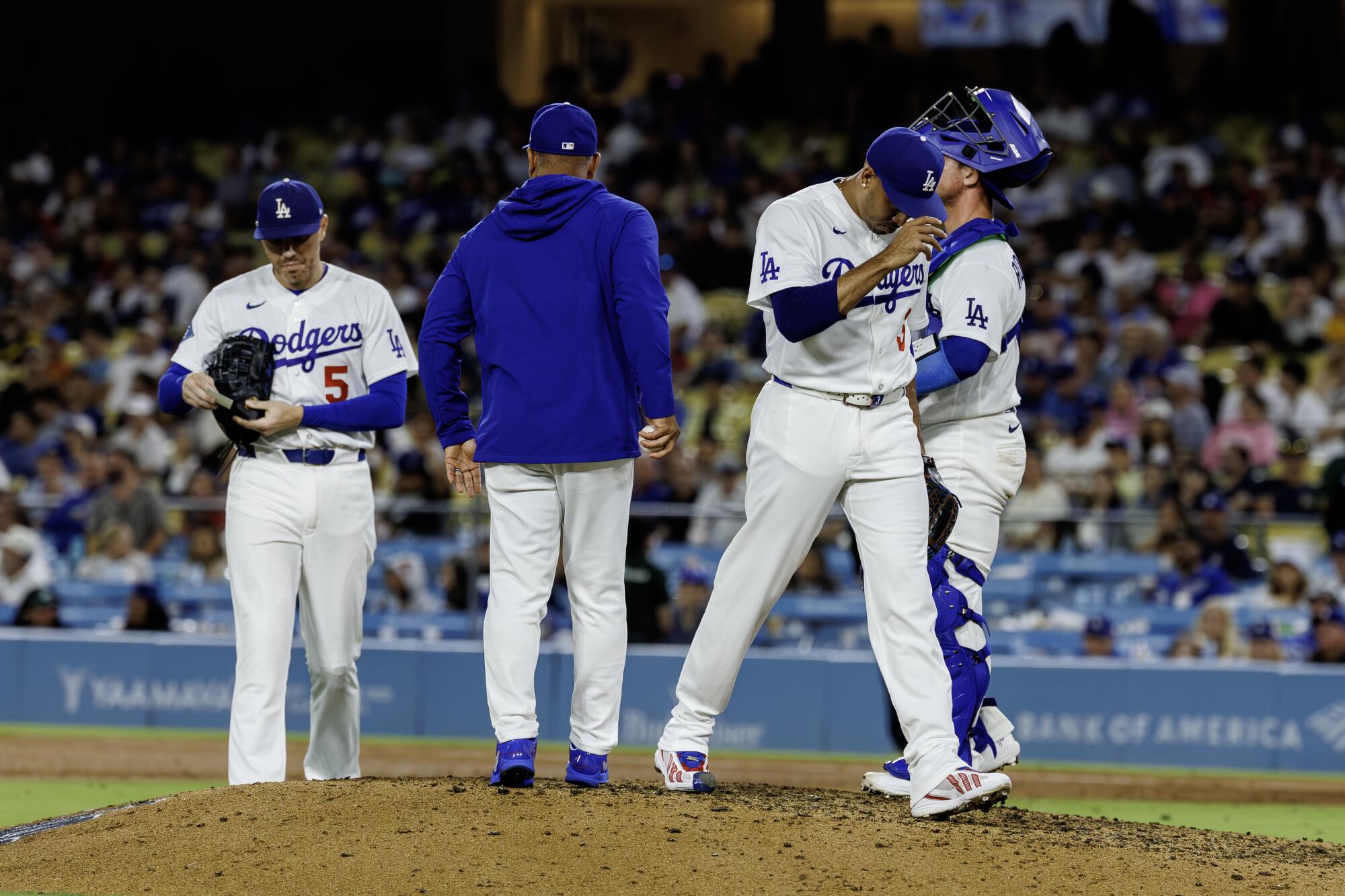 Dodgers manager Dave Roberts, center, pulls closer Edwin Díaz from the game.