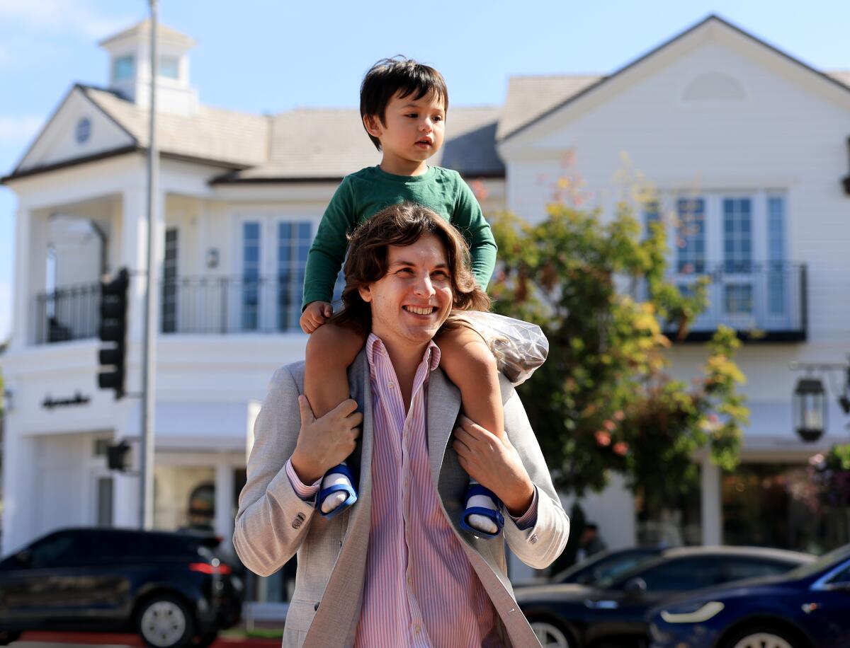 Yves Felker and his son Adam Felker, 2, of Los Angeles, joins crowds attending the grand reopening.
