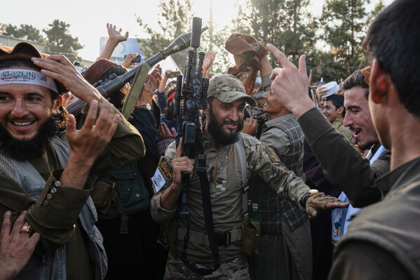 Taliban security personnel dance and cheer during celebrations marking the fifth anniversary of the U.S. withdrawal from Afghanistan and the Taliban's return to power, in Kabul, Afghanistan, Saturday, Aug. 15, 2026. (AP Photo/Nava Jamshidi)
