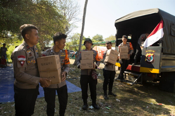 Police officers unload relief goods for earthquake survivors in North Lamba Leda, East Nusa Tenggara province, Indonesia, Tuesday, Aug. 18, 2026. (AP Photo/Firdia Lisnawati)