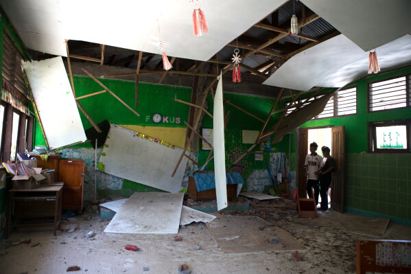 People inspect a class room at an earthquake-damaged school in Reo, East Nusa Tenggara province, Indonesia, Monday, Aug. 17, 2026. (AP Photo/Firdia Lisnawati)