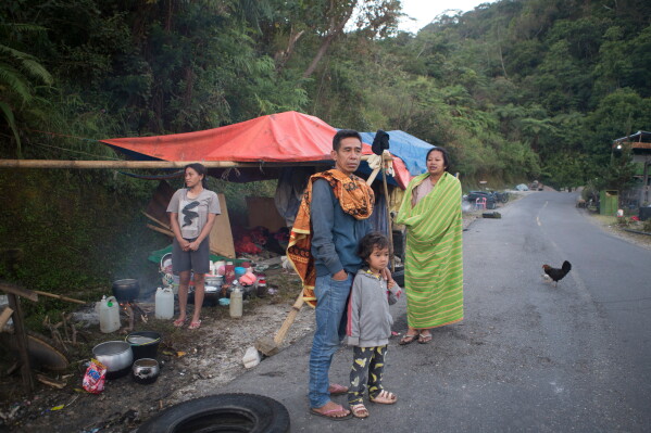 People take shelter in makeshift tent amid fears of aftershocks, following an earthquake in Reo, East Nusa Tenggara province, Indonesia, Monday, Aug. 17, 2026. (AP Photo/Firdia Lisnawati)