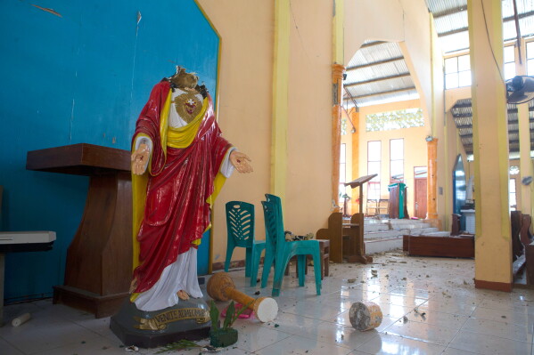 A broken statue of Jesus Christ is seen inside an earthquake-damaged church in Reo, East Nusa Tenggara province, Indonesia, Monday, Aug. 17, 2026. (AP Photo/Firdia Lisnawati)