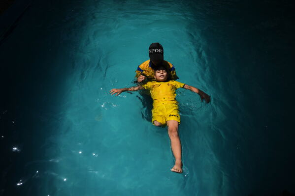 Palestinian girl Miral al-Babli, who lost a leg after being injured during the war between Israel and Hamas, receives swimming training from the Heal Palestine organization at a pool in Khan Younis, Gaza Strip, Thursday, Aug. 20, 2026. (AP Photo/Abdel Kareem Hana)