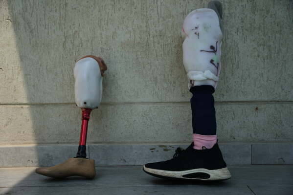 Prosthetic limbs belonging to Palestinian children who lost their legs after being injured in the war between Israel and Hamas are placed beside the pool as the children receive swimming training from the Heal Palestine organization in Khan Younis, Gaza Strip, Thursday, Aug. 20, 2026. (AP Photo/Abdel Kareem Hana)
