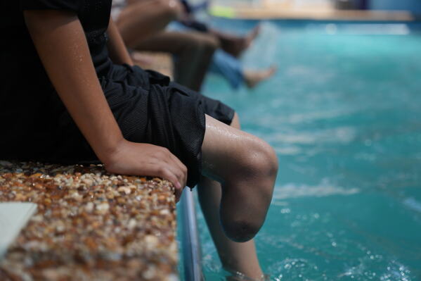 Palestinian girl Sama Abu Khuswan, 12, who lost a leg after being injured in the war between Israel and Hamas, participates in a swimming training session organized by the Heal Palestine organization at a pool in Khan Younis, Gaza Strip, Thursday, Aug. 20, 2026. (AP Photo/Abdel Kareem Hana)