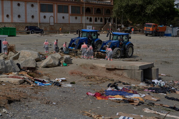 Cleaning staff clear the El Trampolin beach, where migrants who crossed from Morocco into Spain stayed in the Spanish exclave of Ceuta, Thursday, Aug. 20, 2026. (AP Photo/Antonio Sempere)