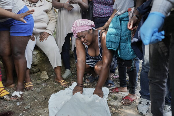 People mourn over the bodies of people they said were their relatives and killed in a gang attack in the Kenscoff neighborhood of Port-au-Prince, Haiti, Monday, Aug. 24, 2026. (AP Photo/Odelyn Joseph)