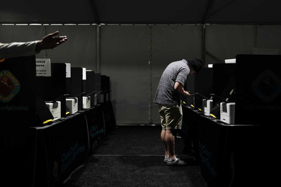 A voter casts a ballot at a vote center set up in a tent in Las Vegas on June 9.