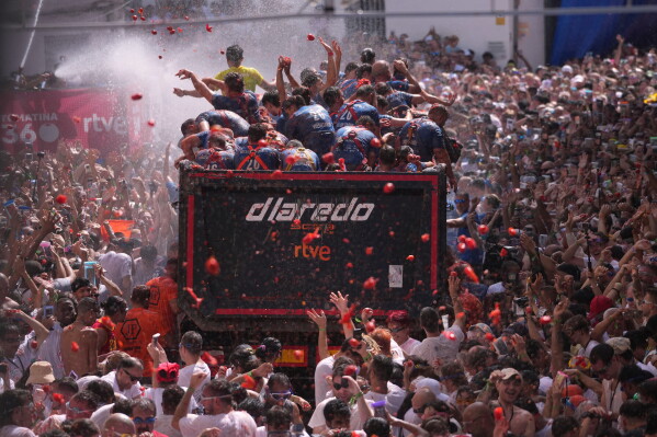 Revelers throw tomatoes at each other during the annual "Tomatina" tomato fight fiesta, in the village of Bunol near Valencia, Spain, Wednesday, Aug. 26, 2026. (AP Photo/Alberto Saiz)