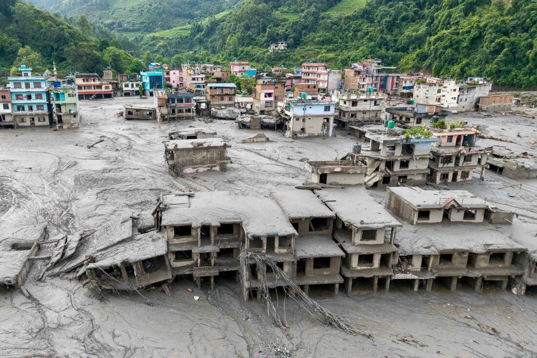 An aerial view shows houses lying deluged in sludge after flash floods at Devighat, Bidur Municipality in Nepal's Nuwakot district on August 27, 2026.