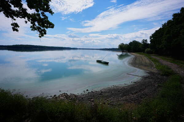 A fishing boat rests on a shore of Rozmberk pond near the town of Trebon, Czech Republic, Wednesday, Aug. 26, 2026. (AP Photo/Petr David Josek)