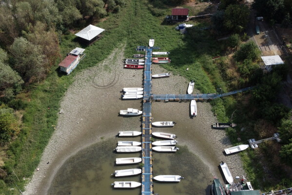 Boats sit on dry ground as water levels have dropped on the Danube River in Petrovaradin, Serbia, Tuesday, Aug. 25, 2026. (AP Photo/Darko Vojinovic)
