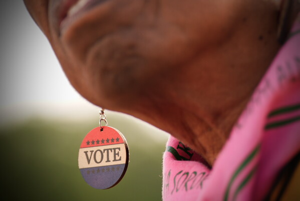 A demonstrator wears "Vote" earrings near the Lincoln Memorial before the March on Washington, Friday, Aug. 28, 2026, in Washington. (AP Photo/Julia Demaree Nikhinson)