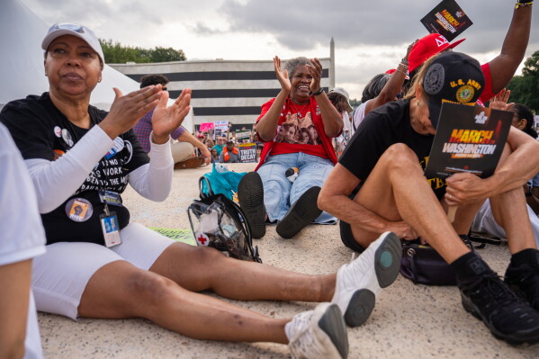 Demonstrators listen to speakers during the March on Washington, Friday, Aug. 28, 2026, near the Lincoln Memorial in Washington. (AP Photo/Julia Demaree Nikhinson)