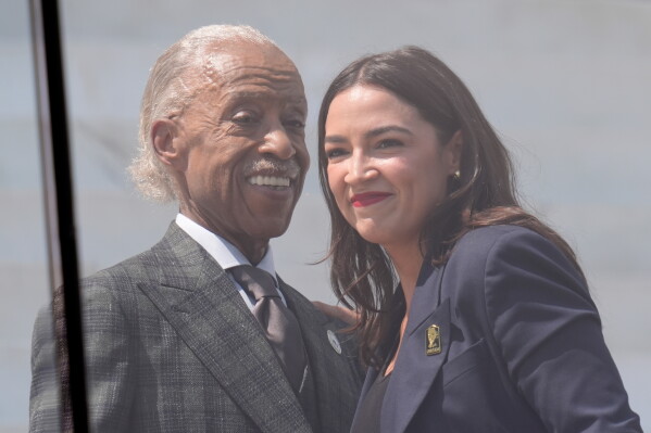 Rev. Al Sharpton, left, and Rep. Alexandria Ocasio-Cortez, D-N.Y, right, on stage together during the March on Washington rally at the Lincoln Memorial on the National Mall, Friday, Aug. 28, 2026 in Washington. (AP Photo/Manuel Balce Ceneta)