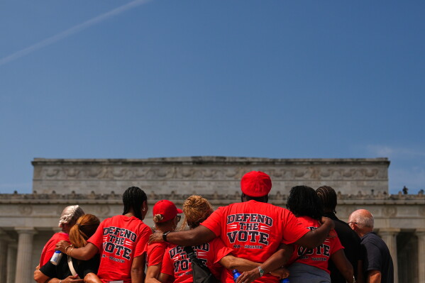 Demonstrators pose for a photo near the Lincoln Memorial during the March on Washington, Friday, Aug. 28, 2026, in Washington. (AP Photo/Julia Demaree Nikhinson)