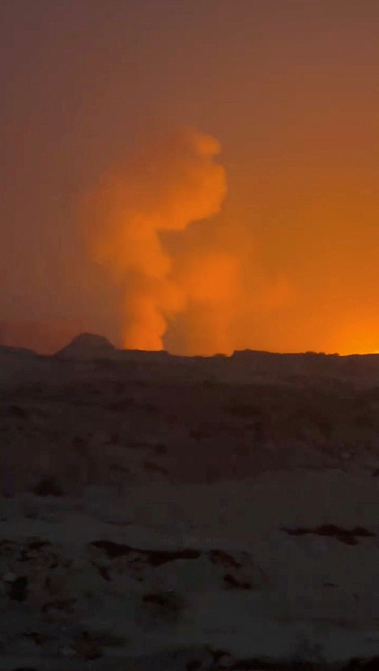 A plume of smoke rises after reported strikes, from Qeshm, Iran, July 30
