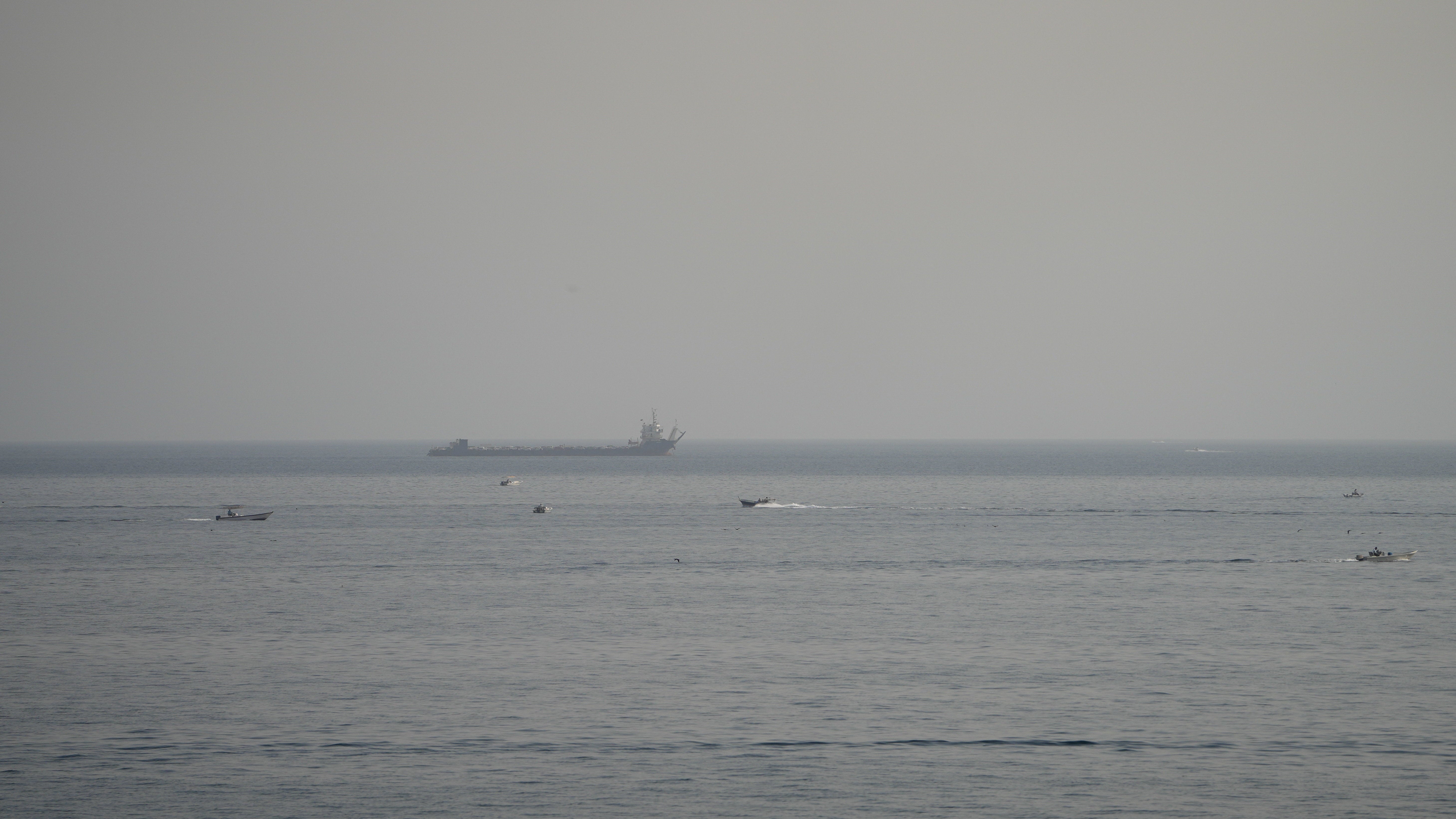 Boats and a vessel in the Strait of Hormuz, as seen from Musandam, Oman, August 3