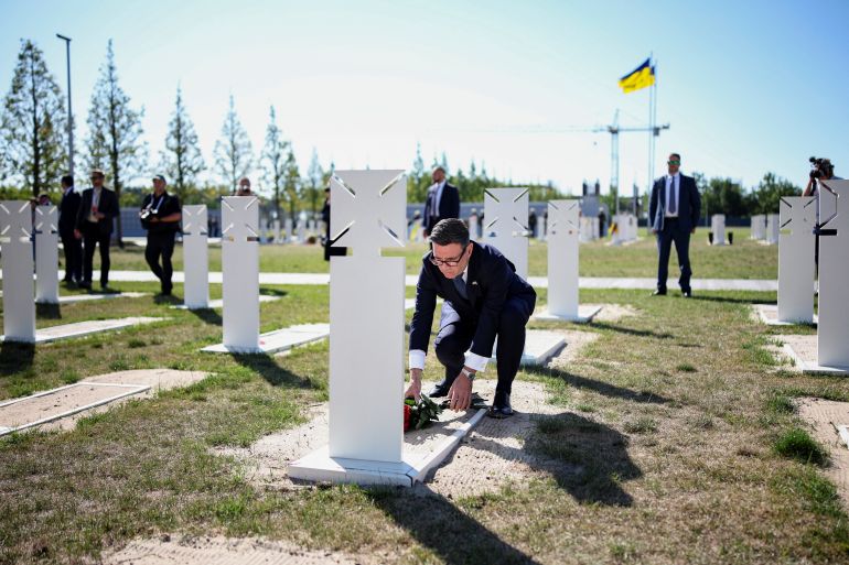 UK Prime Minister Andy Burnham lays flowers at the tomb of the unknown Ukrainian soldier during a ceremony at Ukraine's national military memorial cemetery as the country marks the 35th anniversary of its independence, in Hatne southwest of Kyiv on August 24, 2026 [Henry Nicholls/Pool via Reuters]