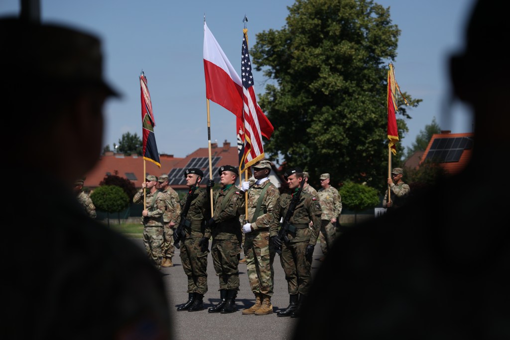 U.S. and Polish soldiers hold their respective flags during a Transfer of Authority Ceremony.