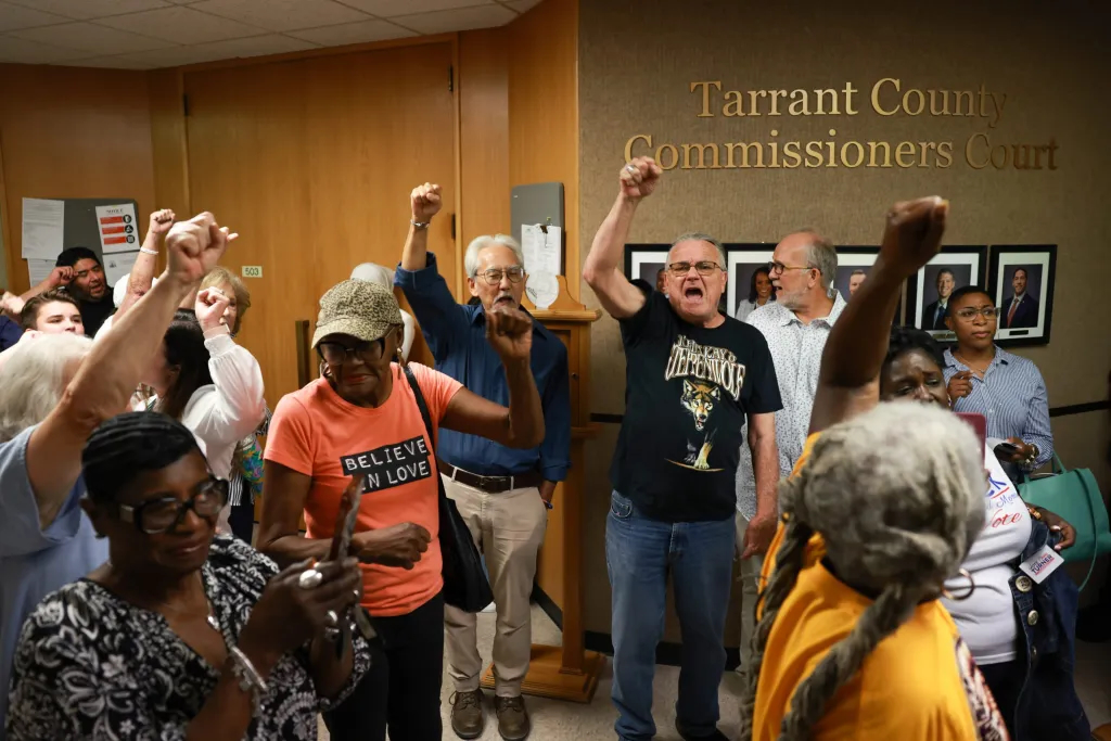 Attendees chant after being removed from the Tarrant County Commissioners Court on Aug. 4, 2026, in Fort Worth.