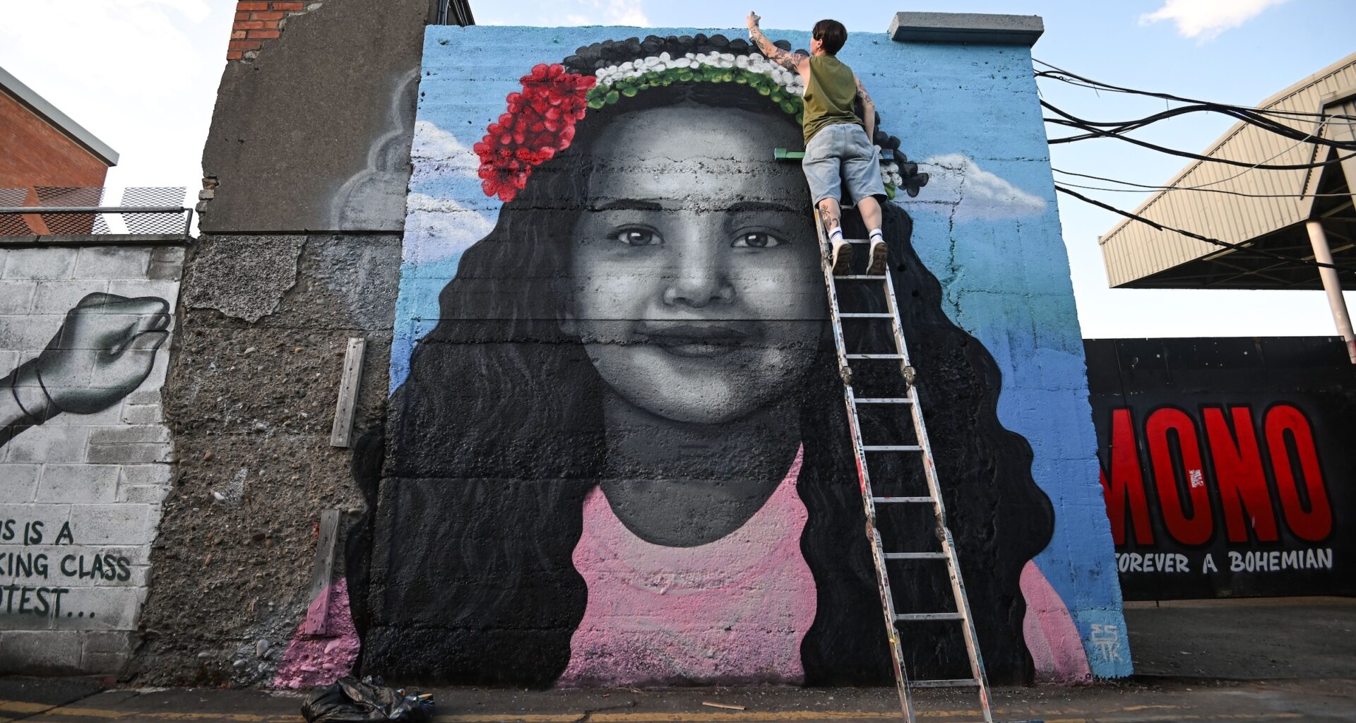 Artist Emmalene Blake puts the final touches to a mural of Hind Rajab, the 6-year-old Palestinian girl who was killed in Gaza, along with several family members and paramedics.