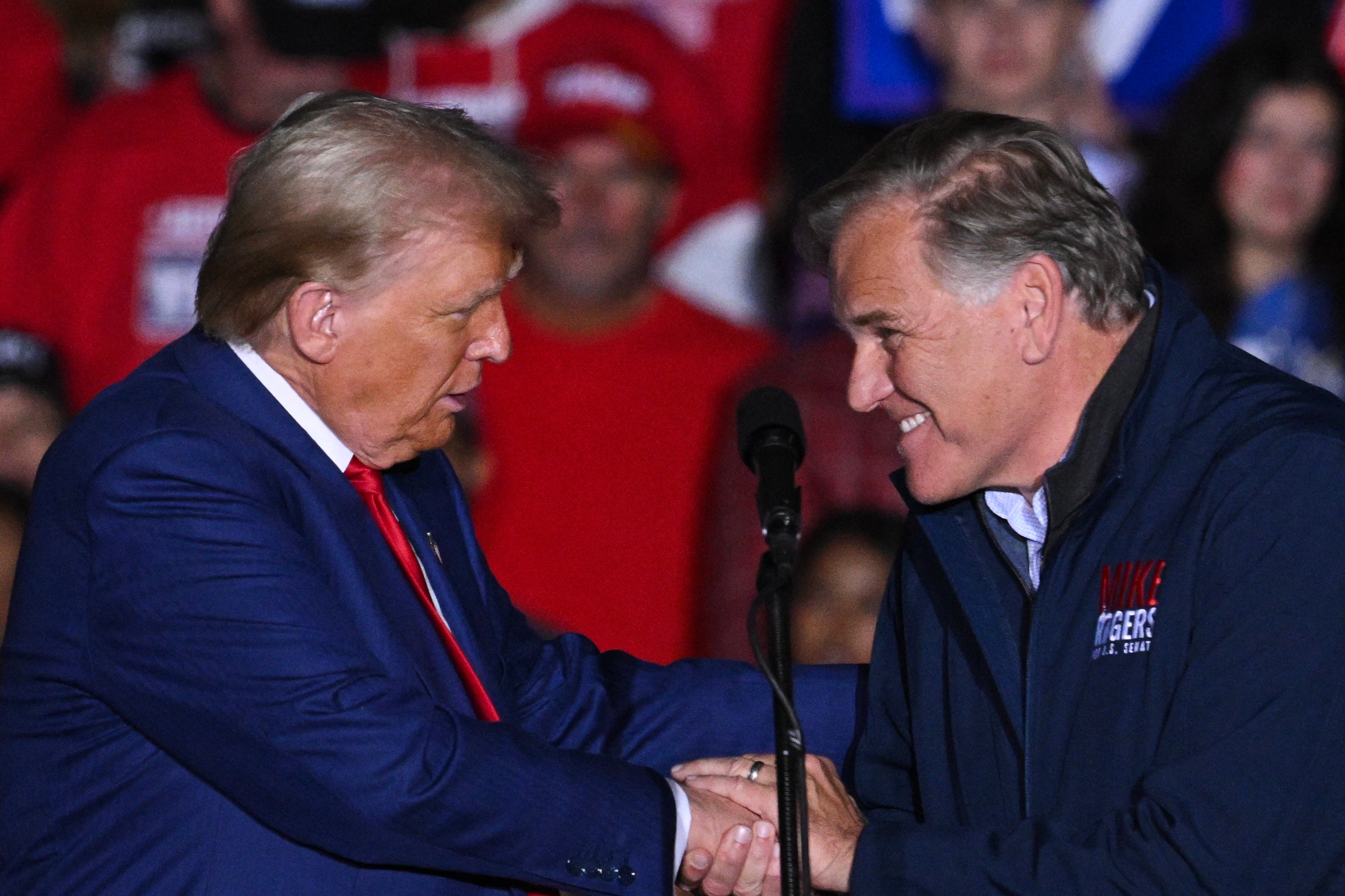Former US President and Republican presidential candidate Donald Trump shakes hands with US Senate candidate Mike Rogers