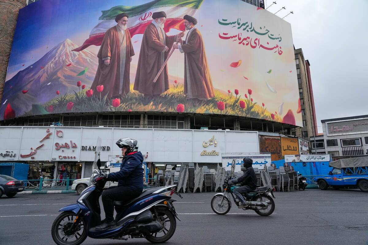 FILE - Motorbikes drive past a billboard depicting Iran's late Supreme Leader Ayatollah Al ...