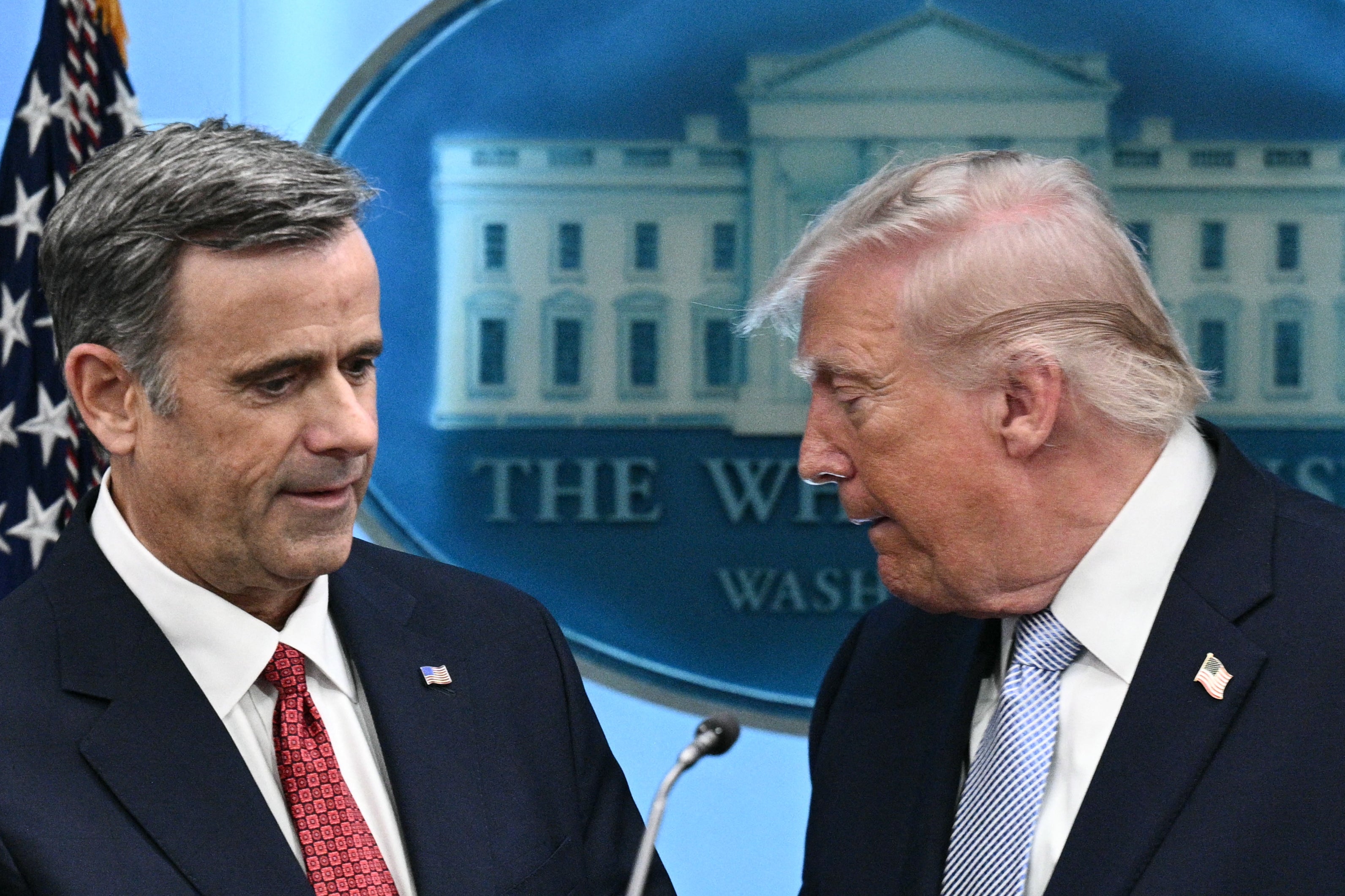 US president Donald Trump (R) cedes the podium to CIA director John Ratcliffe (L) as they speak about the conflict in Iran in the James S. Brady Press Briefing Room of the White House on April 6, 2026, in Washington, DC