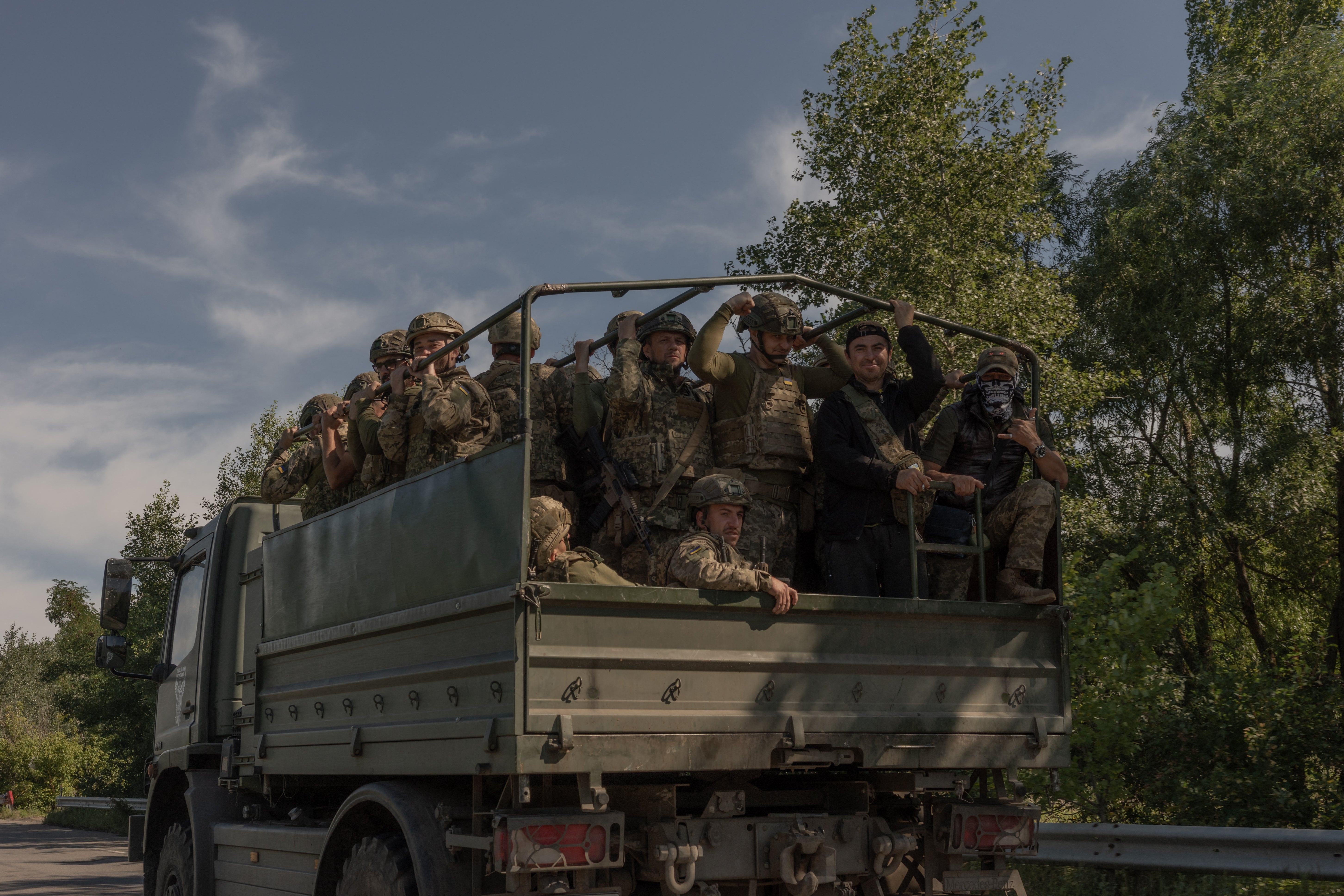 Ukrainian soldiers travel along a road in the Kharkiv region