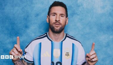 Lionel Messi poses in a photoshoot, with the index fingers of both hands pointing upwards