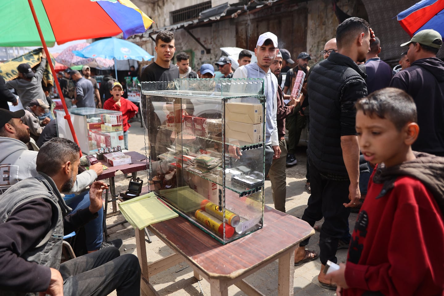 Palestinians walked past a stall selling the few cigarette packets available at the market on Omar Al-Mukhtar Street, in Gaza City on April 19.