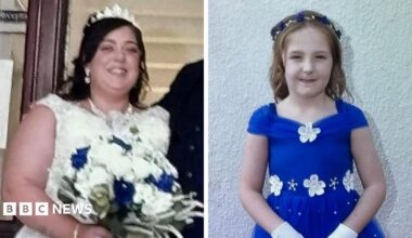 A composite image of Natalie McDonald and Valentina Foster. McDonald is wearing a white wedding dress with a tiara perched on her head. She has long dark hair and is holding a bouquet of white roses with four blue ones dotted within it. Valentina wears an electric blue dress with white flowers on the neckline and waist. She has long light brown hair with a blue and white headband. She is holding a small white basket with white and blue roses and she wears white gloves.