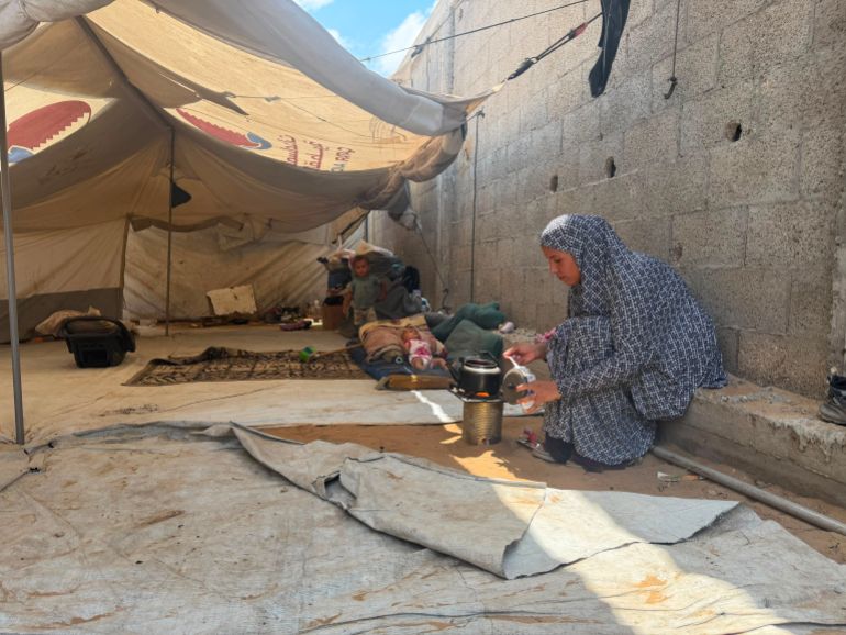 Al-Sahwi family make food in their tent [Hashem Zimmo/Al Jazeera]