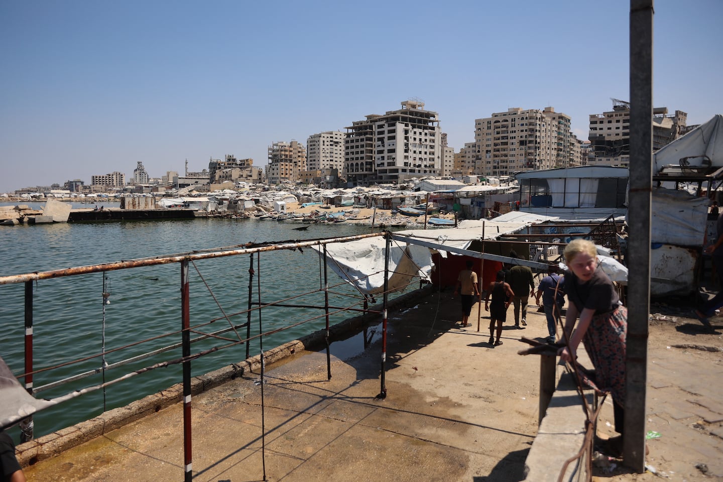 Palestinians stood at a site in Gaza City's port that was targeted by an Israeli army strike the previous day, on Wednesday.