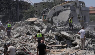 Rescue workers and others gathered at a destroyed house that was hit by an Israeli airstrike in Deir al-Zahrani village, southern Lebanon, on Saturday.