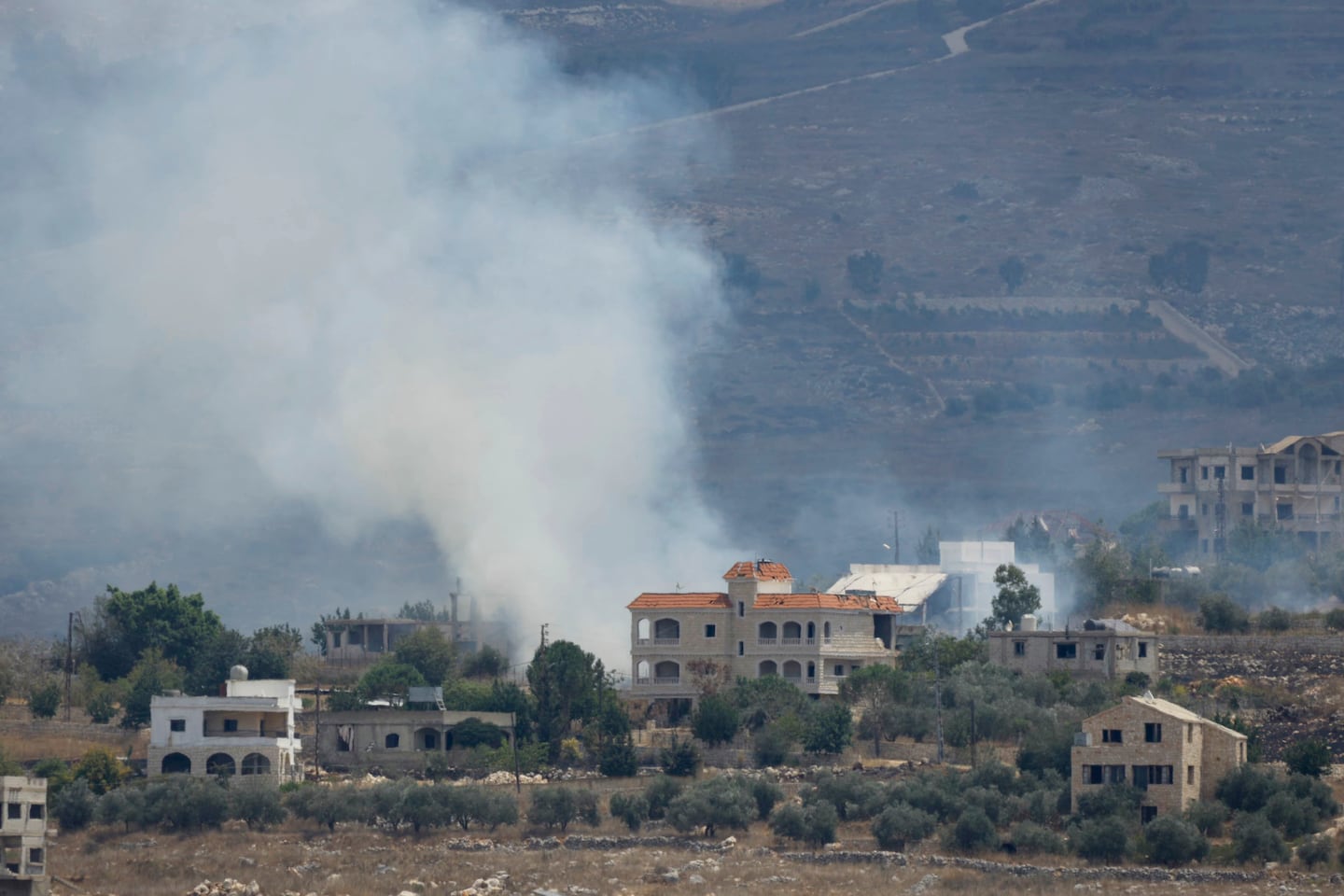 A photograph taken from the southern Lebanese village of Qabrikha shows smoke rising from burning fields in the and destroyed houses in the village of Bani Hayyan, during earlier Israeli military operations and now under it's control, some 10 kilometres from the Lebanon-Israel border on Aug. 14, 2026. Lebanon became embroiled in the Middle East war after Hezbollah fired rockets at Israel on March 2, prompting a widespread Israeli bombing campaign and ground invasion. More than 4,300 people have been killed, though violence has decreased since a US-Iran deal and a Washington-sponsored framework agreement between Lebanon and Israel went into force.