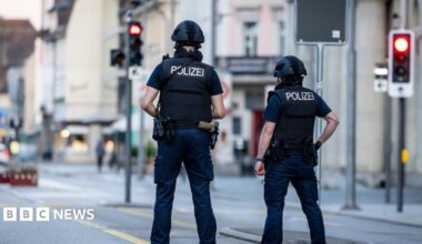 Police officers patroll a street in downtown Aarau