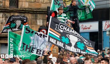 hundreds of celtic flans waving banners in a city centre street