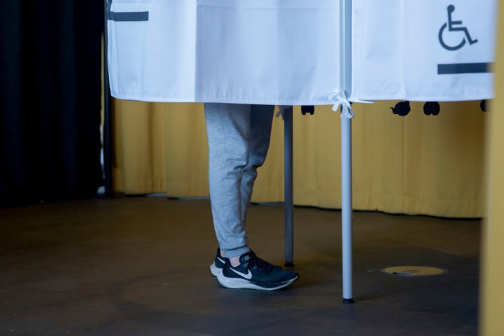 A voter casts a ballot behind a voting screen at Reykjavik City Hall in Reykjavik, Iceland, Saturday, Aug. 29, 2026. (AP Photo/Marco Di Marco)