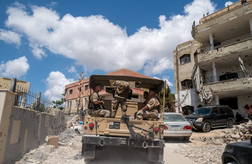 Lebanese army officers on a military vehicle drive in Zawtar al-Gharbiyeh, a village in southern Lebanon, following the deployment of Lebanese soldiers in one of three pilot zones after the withdrawal of Israeli forces under a US-brokered plan, July 26, 2026. 