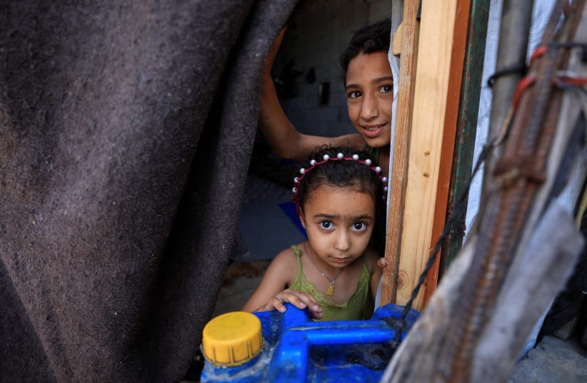 Displaced Palestinian children look out of their shelter in Gaza City, June 15, 2026