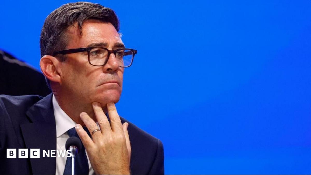 Andy Burnham looks pensive as he puts his hand to his chin and looks sideways.