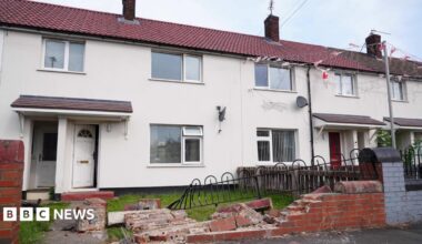 A wall and railing outside a terraced house in Middlesborough is knocked down, with debris strewn across the small garden and path.