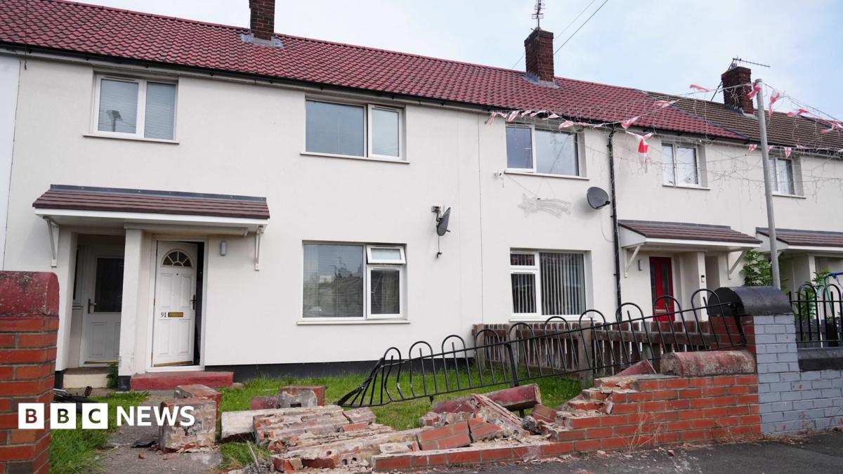 A wall and railing outside a terraced house in Middlesborough is knocked down, with debris strewn across the small garden and path.