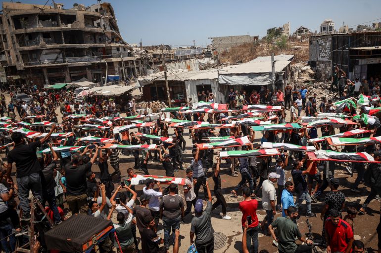 Mourners attend the funeral of the Abu Shreia and al-Hassaina families