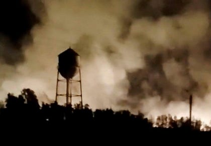 A water tower is silhouetted against smoke rising from a fire following a reported strike in Behbahan, Khuzestan Province, Iran, in this still image obtained from a social media video released in July.